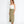 Woman wearing a white top and green skirt on a white background