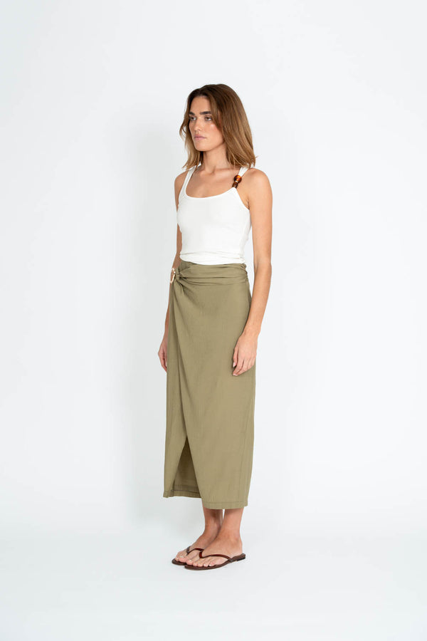 Woman wearing a white top and green skirt on a white background