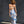 Woman wearing a blue and white sarong standing against a dark wall.