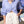 Woman wearing a blue striped shirt and white lace shorts outdoors.
